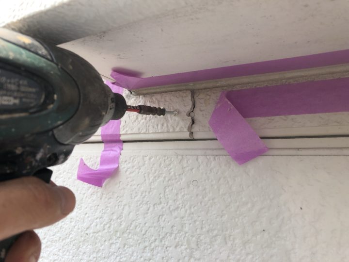 外壁浮き部分ビス打ち作業中